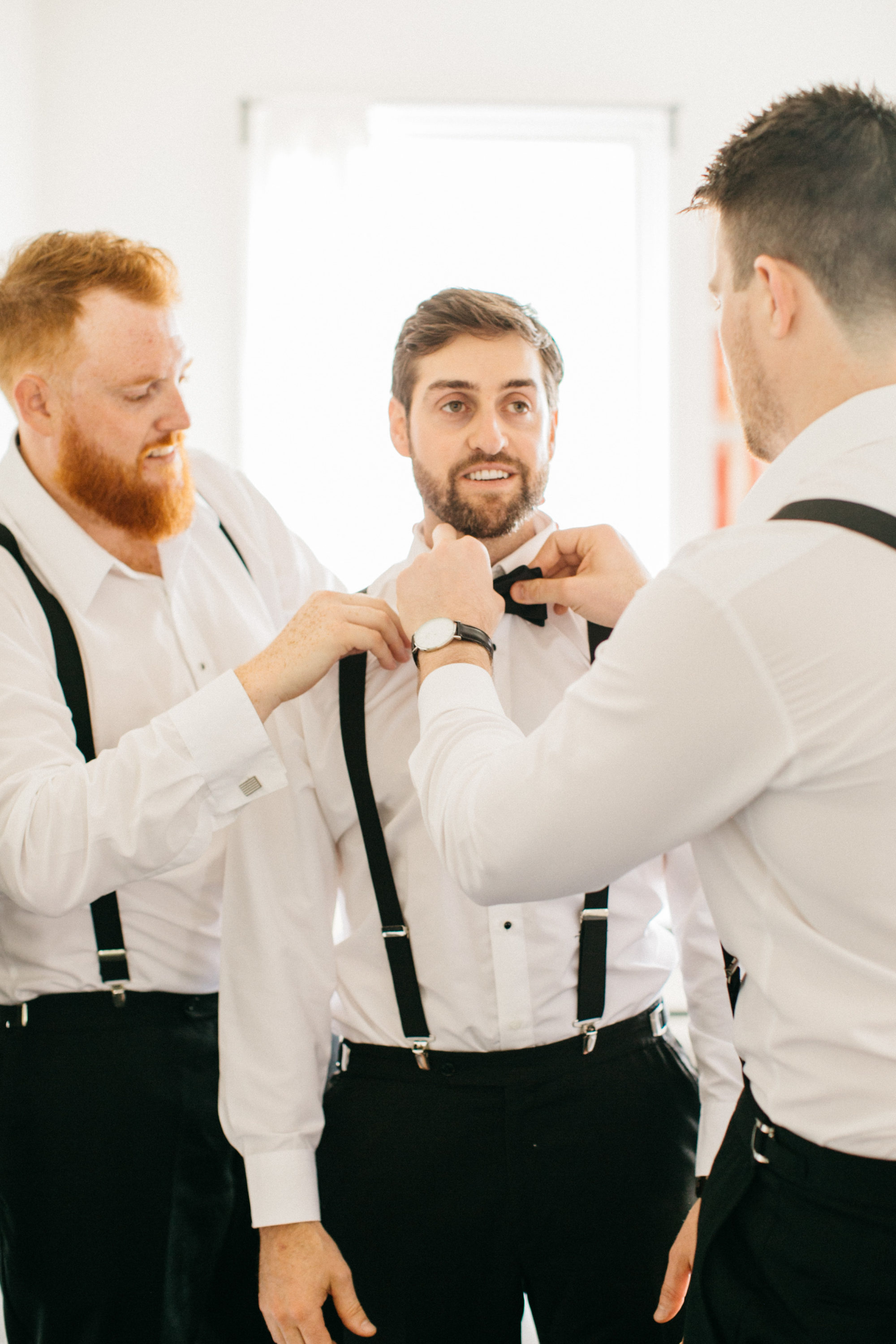 Groomsmen helping groom get ready
