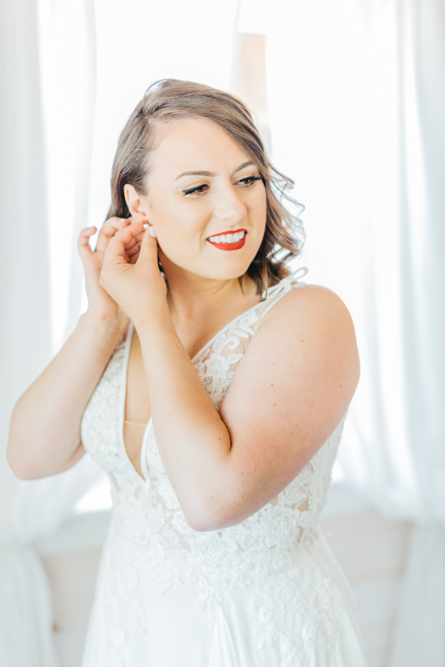 Bride putting earrings in at cottage cabin at Stonewall Estates