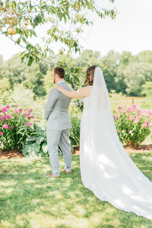 Bride tapping on groom's shoulder in first look
