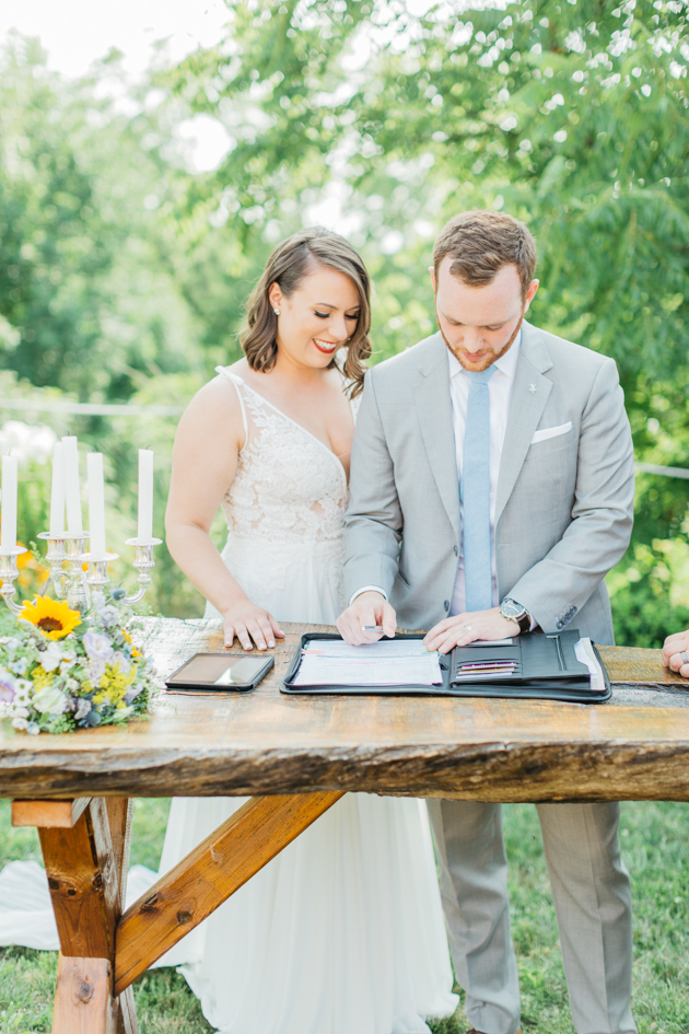 Groom signing wedding papers at Stonewall Estates