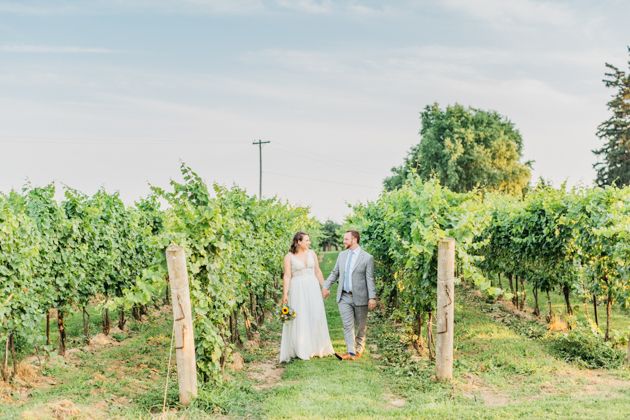 Bride and groom walking through vineyard at Stonewall Estates